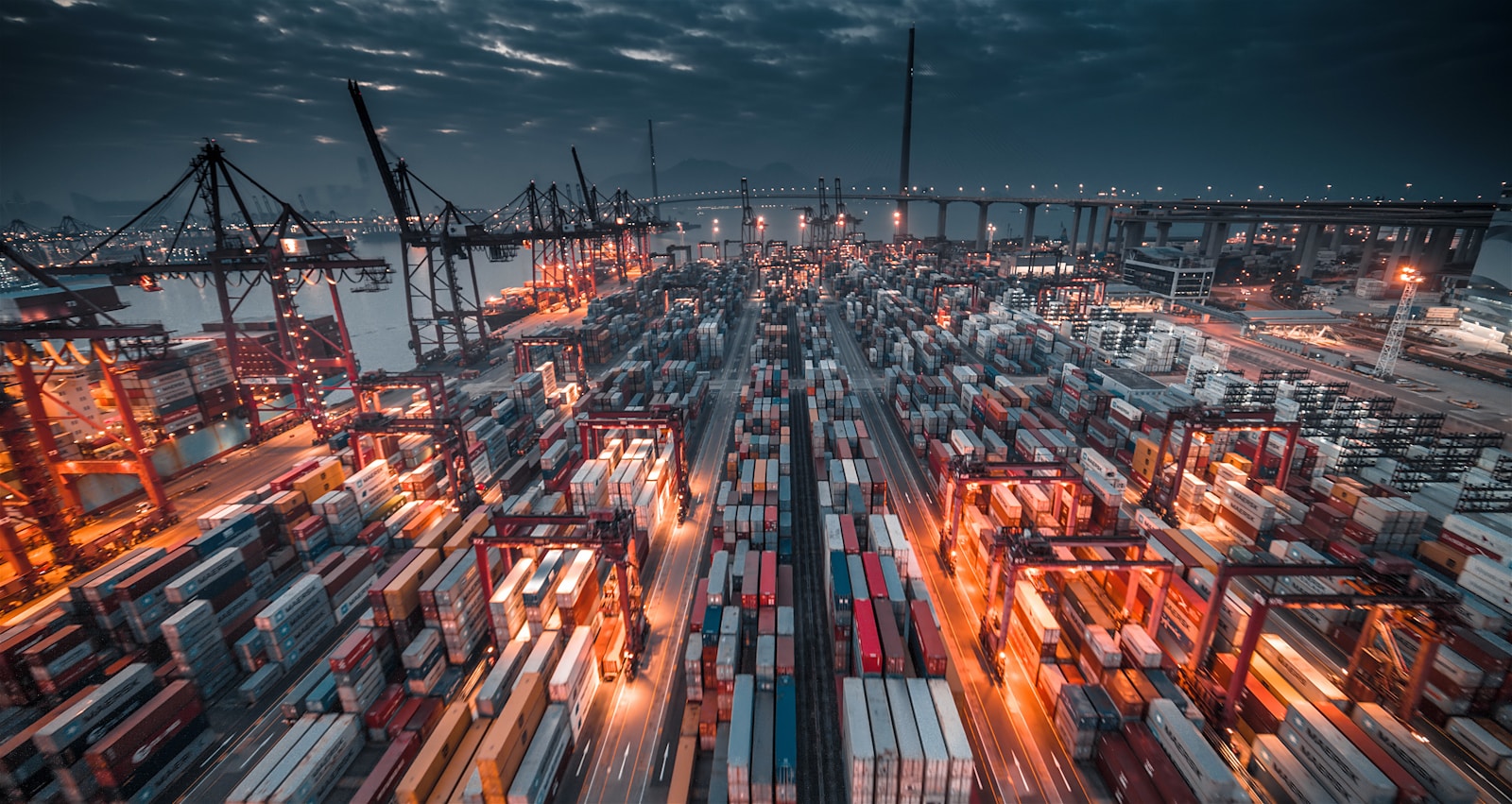 Stacked cargo freight containers at a sea port, representing commerce logistics and fulfillment at scale